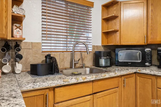 a kitchen with granite countertop a sink a granite counter tops and a wooden floors