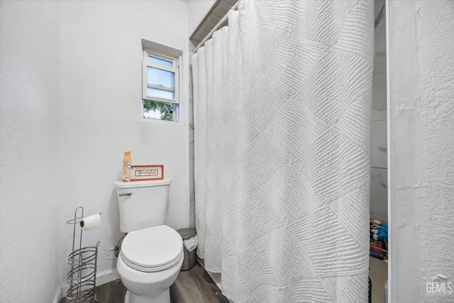 a white toilet sitting next to a shower curtain