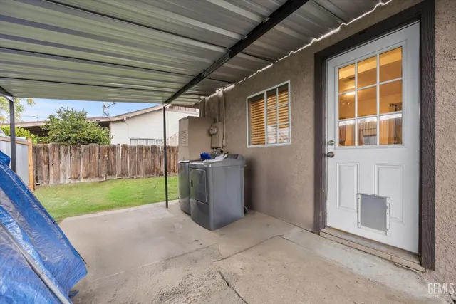 a view of a backyard with wooden fence and a porch