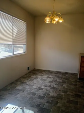 a view of a room with a chandelier fan and a window