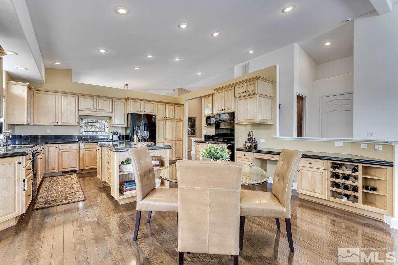 4370 Juniper Trail Reno, NV 89519 - Photo 16 of 40 a kitchen with stainless steel appliances granite countertop a stove top oven a sink a dining table and chairs