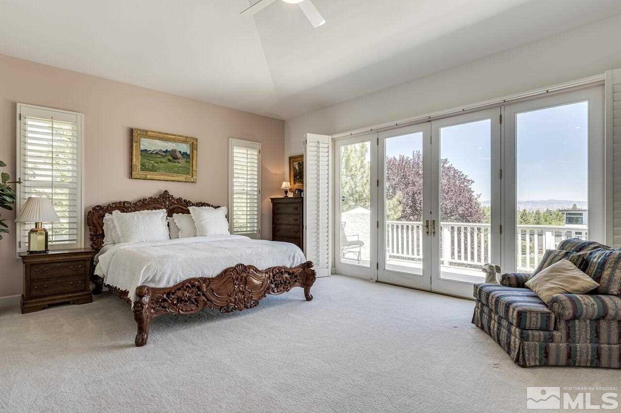4370 Juniper Trail Reno, NV 89519 - Photo 24 of 40 a spacious bedroom with a bed and a couch next to a window
