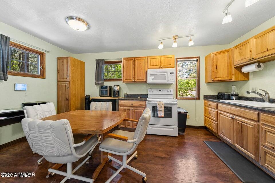 5801 Apache Trail Pinetop, AZ 85935 - Photo 14 of 39 a kitchen with granite countertop kitchen island stainless steel appliances a stove a sink a refrigerator dining table and chairs