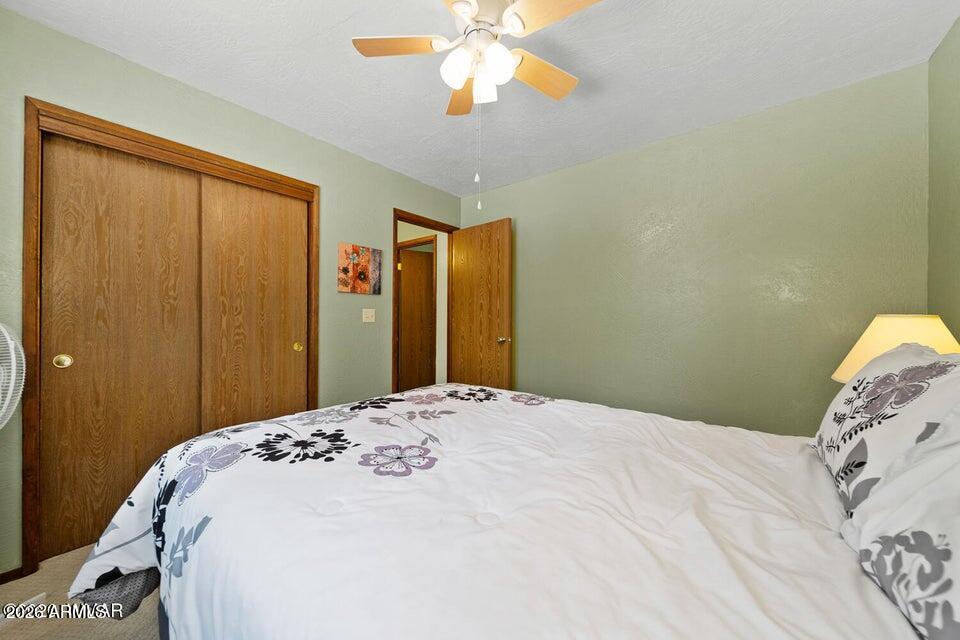 5801 Apache Trail Pinetop, AZ 85935 - Photo 26 of 39 a bedroom with a large bed and a chandelier