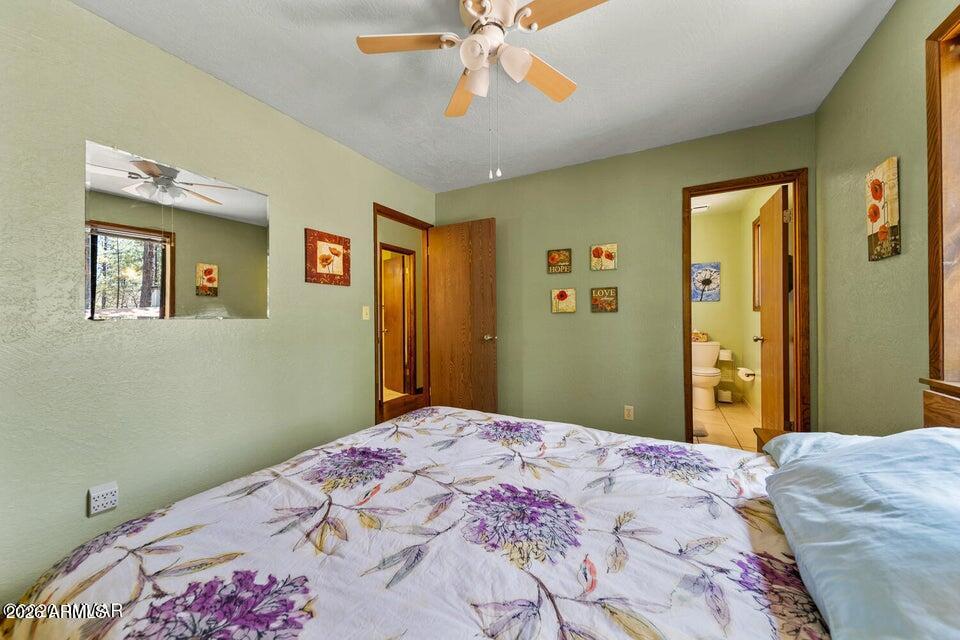 5801 Apache Trail Pinetop, AZ 85935 - Photo 28 of 39 a bedroom with a large bed and a chandelier