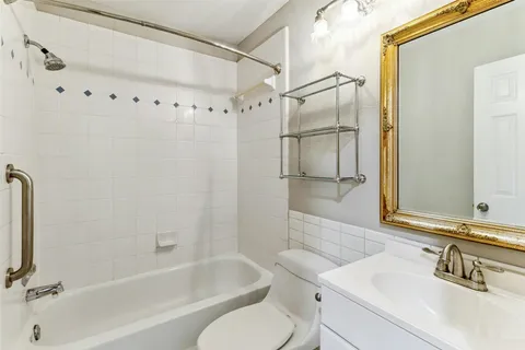a bathroom with a granite countertop sink mirror toilet and bathtub