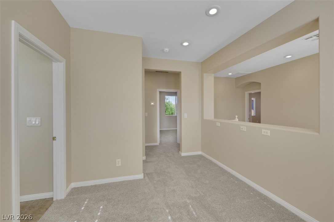 10328 Hawk Ravine Street Las Vegas, NV 89178 - Photo 26 of 55 A versatile upper-level landing, perfect for an office or lounge, boasts soft carpeting and recessed lighting.