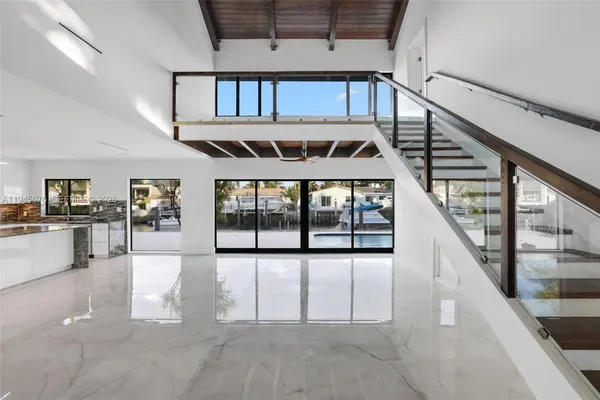 front view of a house with a yard and palm trees