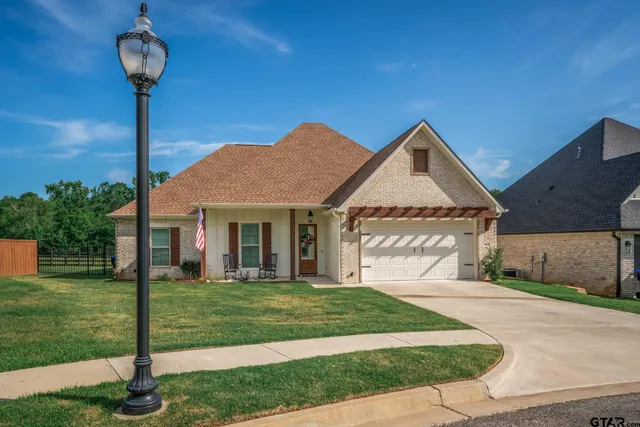 a front view of a house with a garden and yard