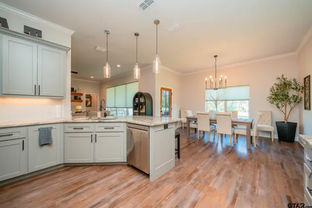 a open kitchen with a dining table chairs and white cabinets