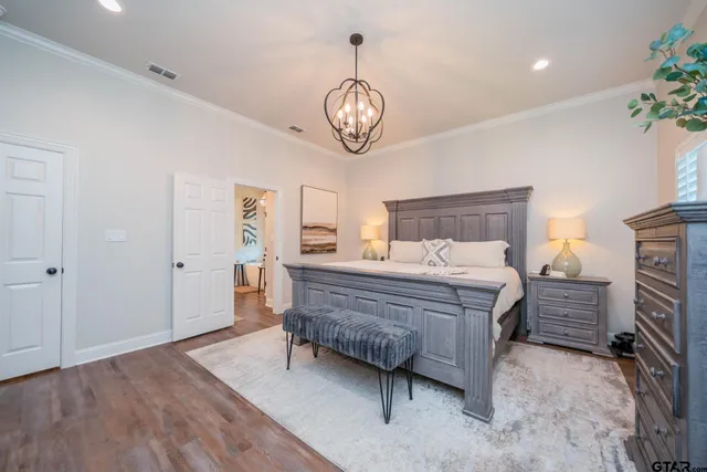 a bedroom with a bed and a chandelier