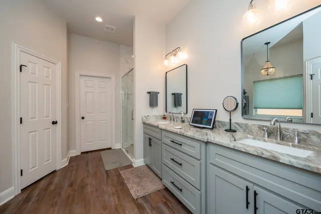a spacious bathroom with a granite countertop sink mirror and shower