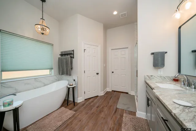 a bathroom with a granite countertop sink a toilet a tub and shower