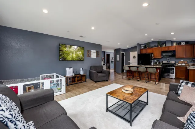 a living room with furniture a flat screen tv and a chandelier