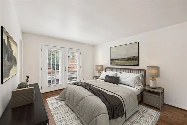 a bedroom with a bed and a couch with wooden floor