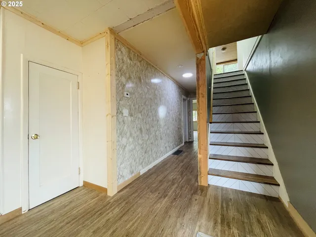 a view of a hallway with wooden floor and entryway