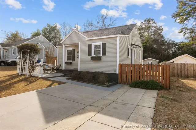 a view of a house with a small yard and wooden fence
