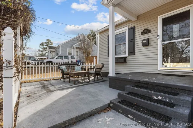 a roof deck with a couch and wooden fence