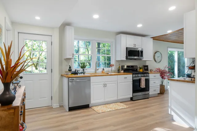 a kitchen with stainless steel appliances granite countertop a stove a sink and a refrigerator