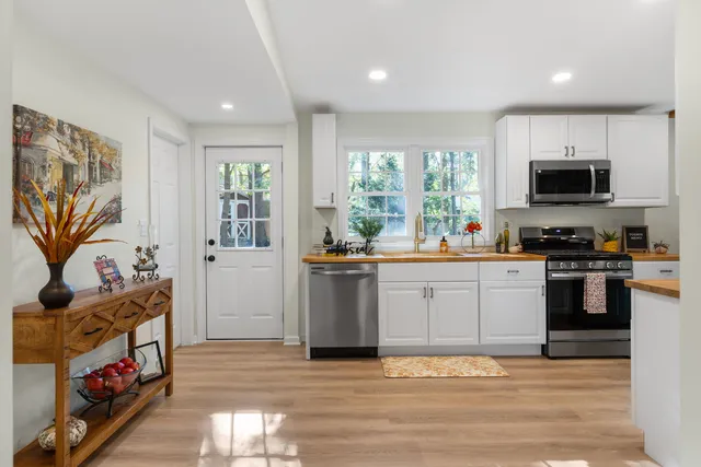 a kitchen with stainless steel appliances a stove top oven a sink and a refrigerator