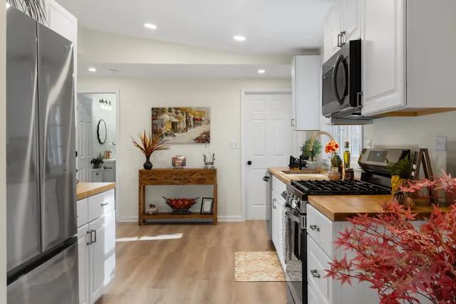 a kitchen with stainless steel appliances granite countertop a refrigerator a stove top oven a sink and dishwasher