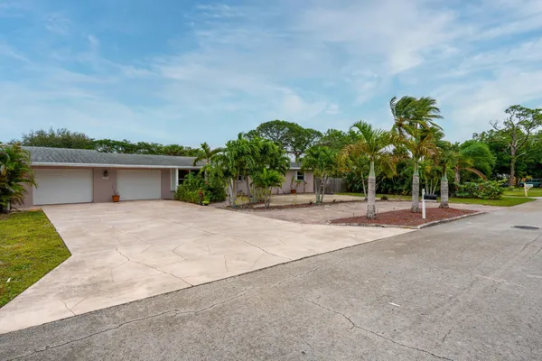 front view of a house with a yard and a garage
