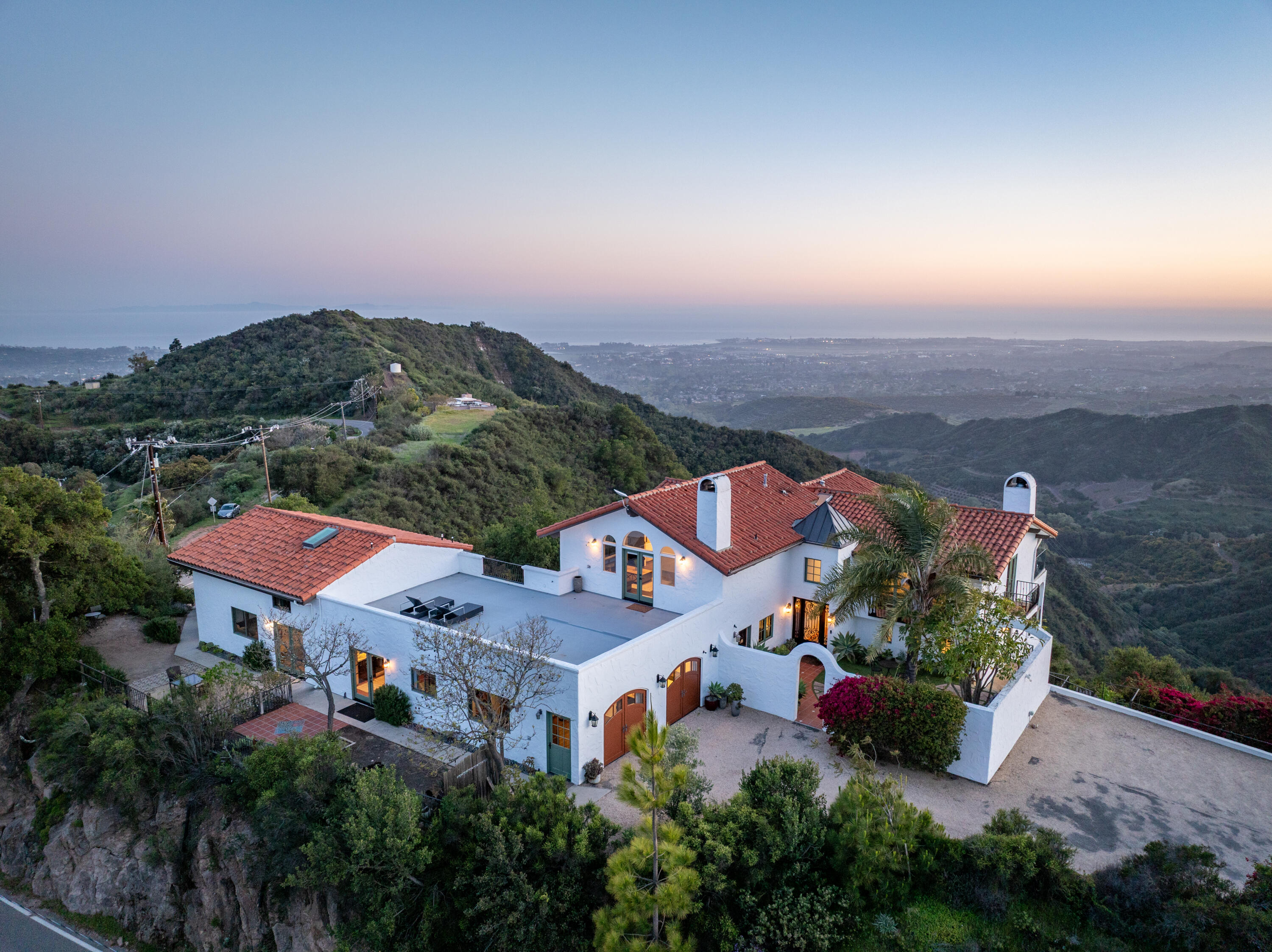 an aerial view of residential houses with outdoor space and trees