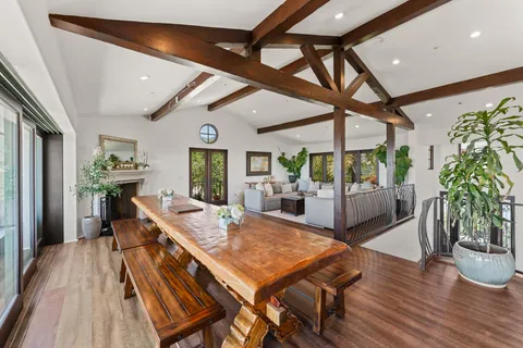 a dining room with furniture a fireplace and wooden floor