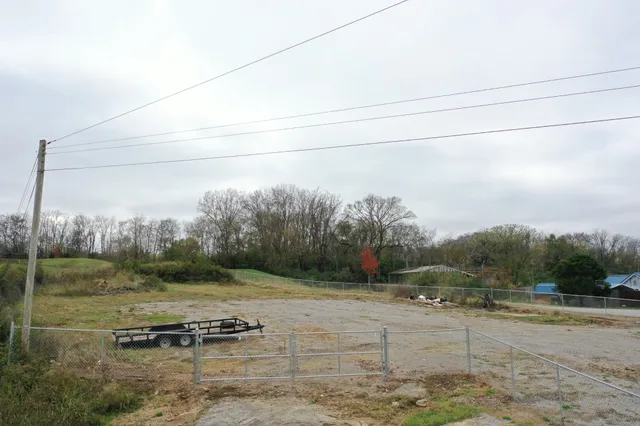 a view of a dry yard with wooden fence