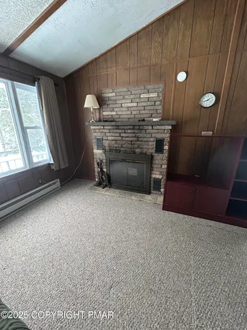 a view of an empty room with a fireplace and a window