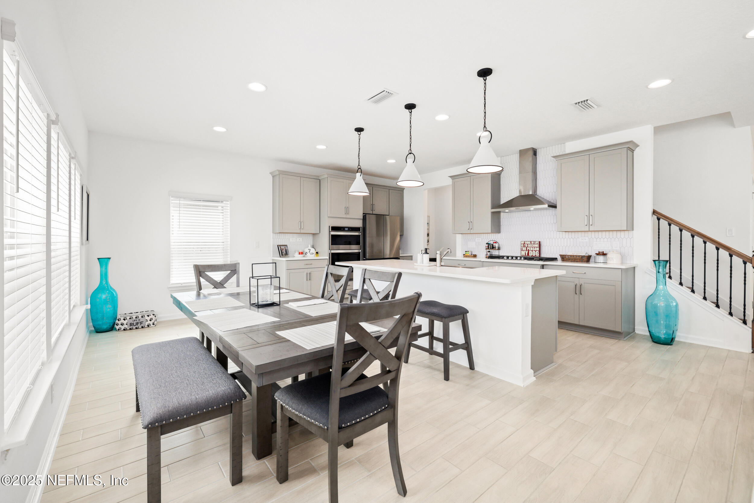 219 Goldcrest Way St. Augustine, FL 32092 - Photo 15 of 55 a kitchen with a dining table chairs and white cabinets