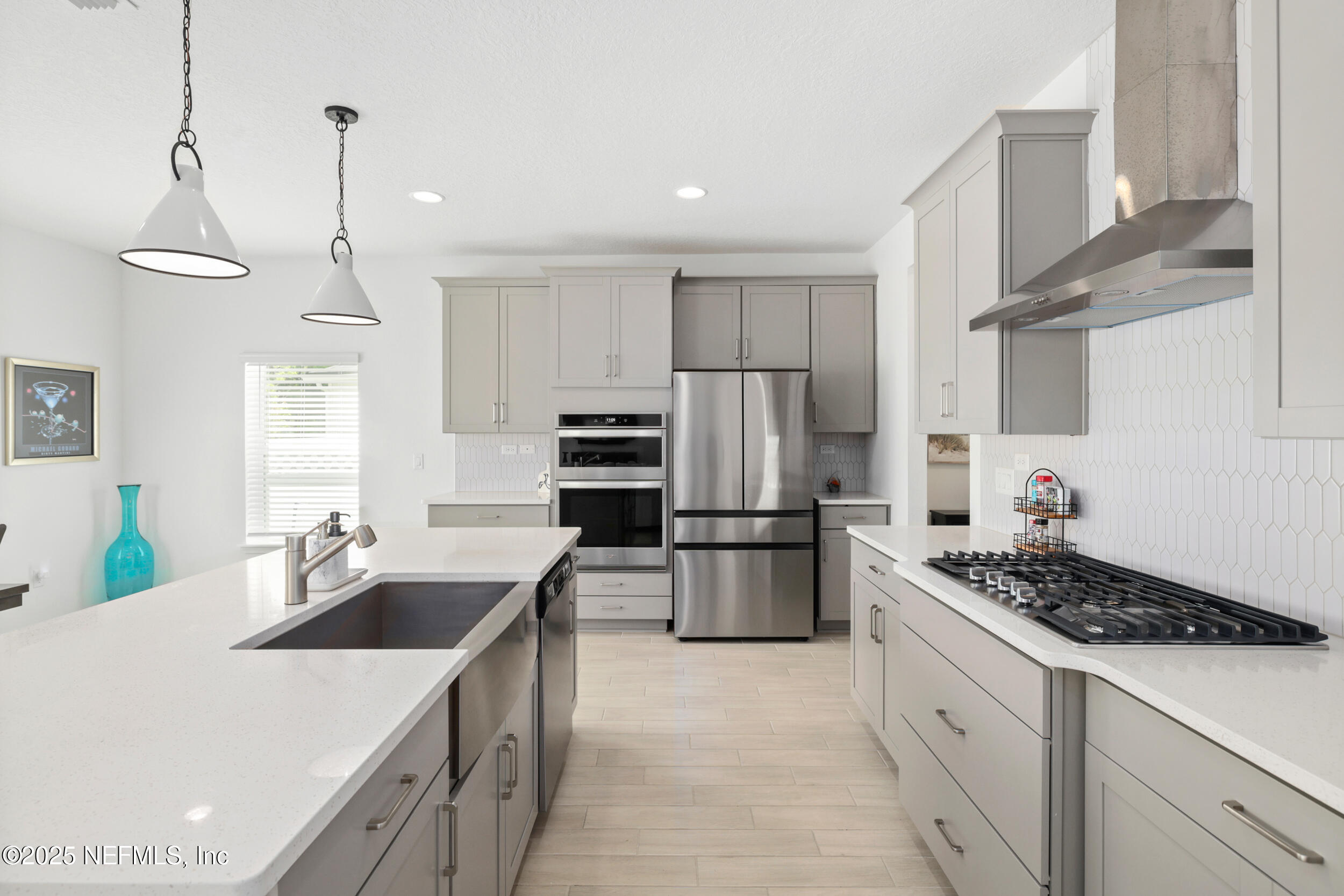 219 Goldcrest Way St. Augustine, FL 32092 - Photo 18 of 55 a kitchen with refrigerator a stove a sink dishwasher and white cabinets with wooden floor