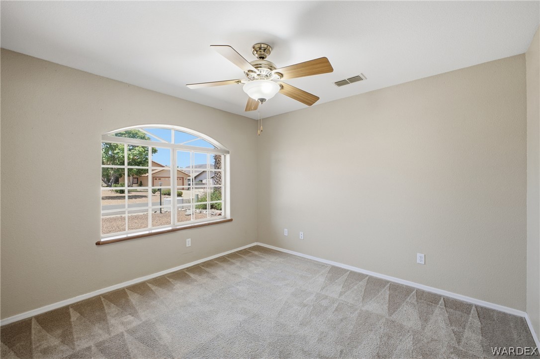 3918 North Eagle Rock Road Kingman, AZ 86409 - Photo 13 of 44 an empty room with windows and fan