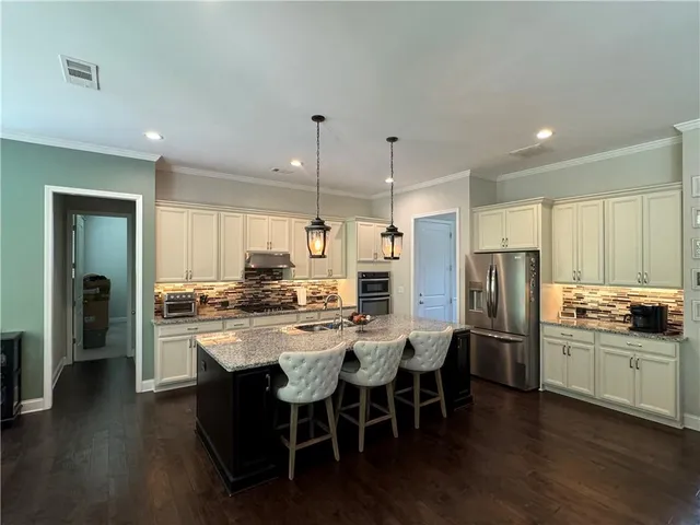 a large kitchen with stainless steel appliances kitchen island granite countertop a large counter top and stove