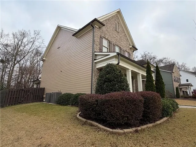a view of a house with backyard and sitting area