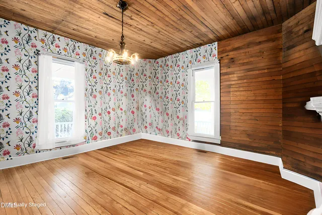 a view of a room with wooden floor fireplace and windows