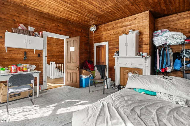 a bedroom with bed and a refrigerator