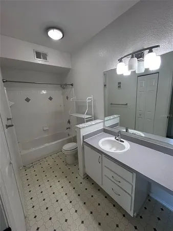 a bathroom with a sink a toilet a mirror and shower