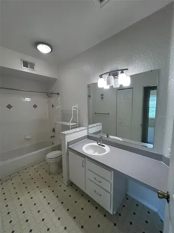 a bathroom with a sink a toilet a large mirror and shower