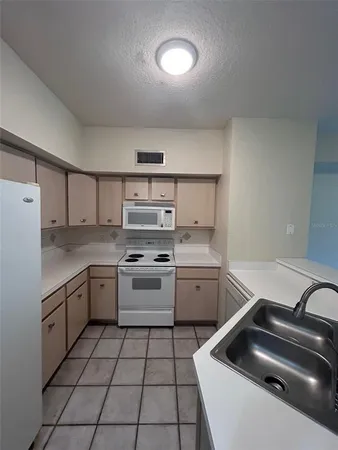 a kitchen with a stove sink and cabinets