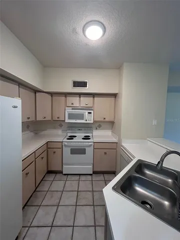 a kitchen with a stove sink and cabinets