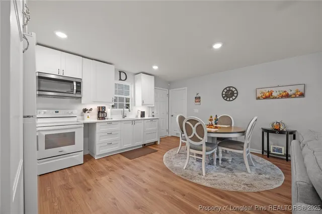 a kitchen with a dining table chairs and white appliances