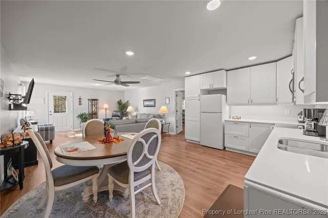 a kitchen with a dining table chairs and refrigerator