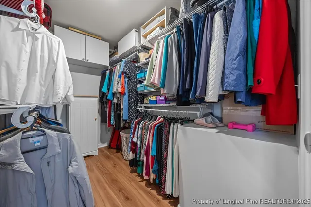 a view of walk in closet with clothes