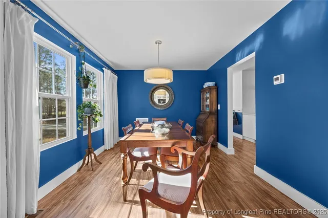 a dining room with wooden floor and chandelier