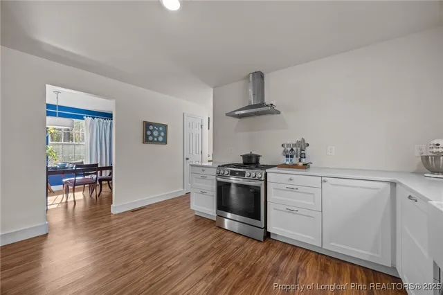 a kitchen with granite countertop a stove and a wooden floors