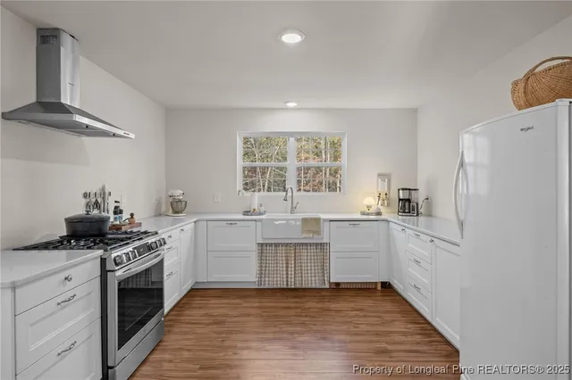 a kitchen with white cabinets and white appliances
