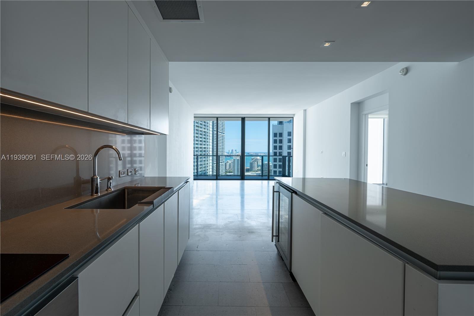 68 Southeast 6th Street, Unit 2507 Miami, FL 33131 - Photo 9 of 47 a kitchen with granite countertop a sink and cabinets with wooden floor