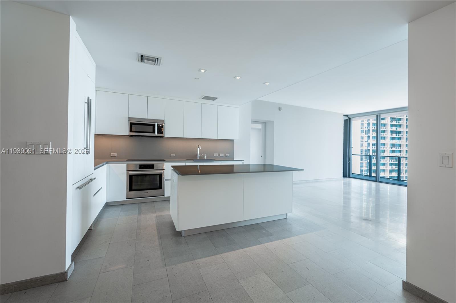 68 Southeast 6th Street, Unit 2507 Miami, FL 33131 - Photo 10 of 47 a kitchen with stainless steel appliances a refrigerator sink and white cabinets