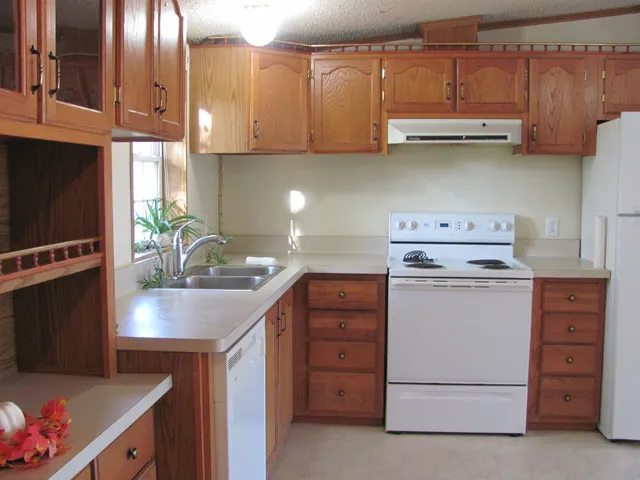 a kitchen with cabinets appliances a sink and a window